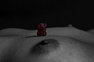 Aktfoto Brust mit rotem Gummibärchen