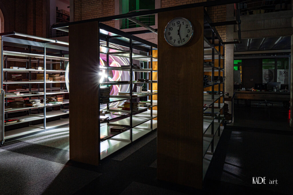 Lightpainting in der Bibliotheca Albertina Pinker Orb hinter einem Bücherregal