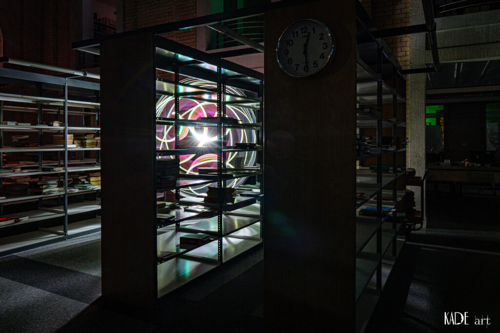 Lightpainting in der Bibliotheca Albertina Pinker Orb hinter einem Bücherregal