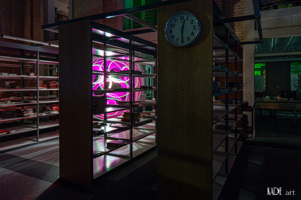 Lightpainting in der Bibliotheca Albertina Pinker Orb hinter einem Bücherregal