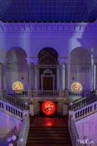 Lightpainting in der Bibliotheca Albertina 3 Orbs (Kugeln) im Foyer der Bibliotheca Albertina. auf der galerie sind 2 Orbs (einer rechts einer links) zwischen den impolsanten Marmorsäulen platziert. Die beiden Orbs sind in Orange und gelb, Beide wurden im Strobomodus erstellt. Auf der mittleren Ebene befindet sich ein Roter Spiralorb