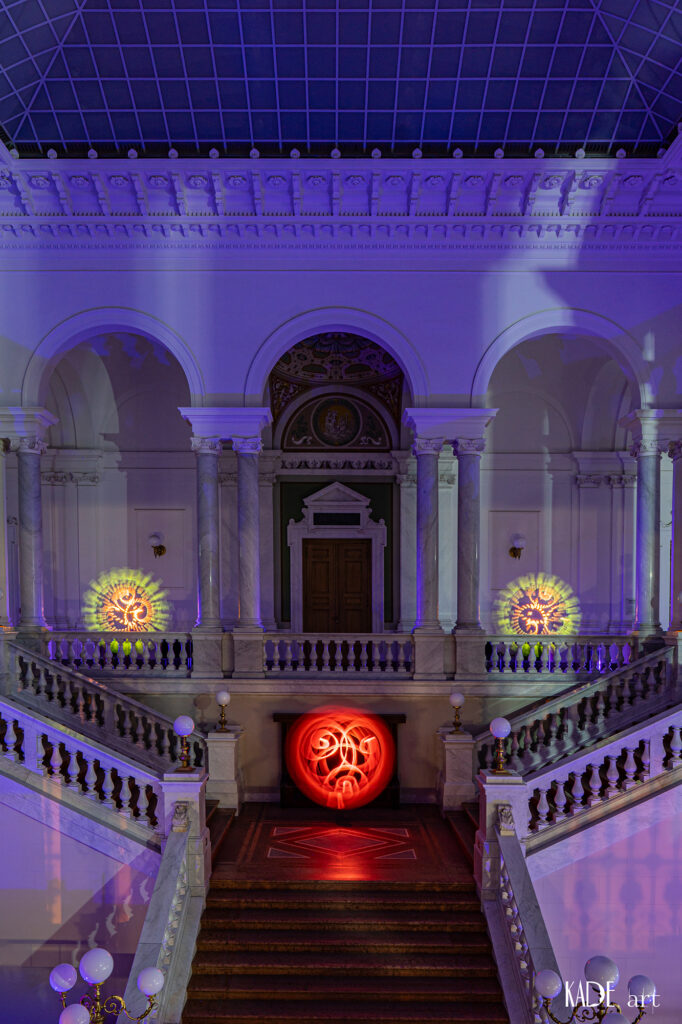Lightpainting in der Bibliotheca Albertina 3 Orbs (Kugeln) im Foyer der Bibliotheca Albertina. auf der galerie sind 2 Orbs (einer rechts einer links) zwischen den impolsanten Marmorsäulen platziert. Die beiden Orbs sind in Orange und gelb, Beide wurden im Strobomodus erstellt. Auf der mittleren Ebene befindet sich ein Roter Spiralorb