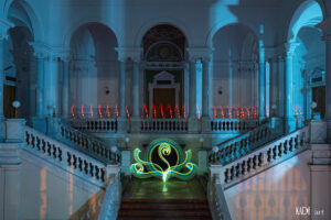 Lightpainting in der Bibliotheca Albertina Auf der oberen Galerie wurde wieder ein Spiraltunnel in Rot gezogen. Auf der mittleren Ebene, vor der Schneiderbank habe ich ein florales Element gesteztz. Es hat die Farben gelb und blau und wirkt dadurch grün
